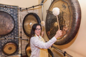 Laura Guru Karam Benton playing the gong with two mallets