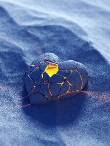 broken heart that has been put back together is laying in the sand with a light inside of it